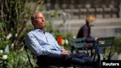 A person sits in Bryant Park after the Centers for Disease Control and Prevention announced new guidelines regarding outdoor mask-wearing and vaccination during the outbreak of the coronavirus, in Manhattan, New York City, New York, April 27, 2021.