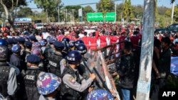 Police block protesters as they gather near a statue of General Aung San during a demonstration in Loikaw, Myanmar, Feb. 12, 2019.