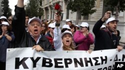 Employees of Greece's health system shout slogans as the banner reads ''Government'' during a protest against government health cuts in Athens, April 17, 2013. 