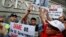 Demonstrators hold signs and a picture supporting Edward Snowden outside the Consulate General of the United States in Hong Kong, June 13, 2013.