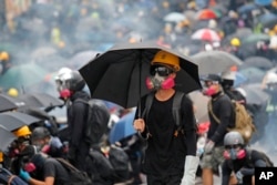 FILE - Protesters face police on a street during a pro-democracy protest in Hong Kong on Aug. 31, 2019.