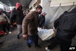 People carry away the body of a person killed in an Israeli bombardment, at the Najjar hospital in Rafah, Gaza Strip, on Feb. 3, 2024.