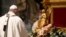 Pope Francis stands in front of a statue of Baby Jesus as he celebrates Mass on Christmas Eve at St. Peter's basilica at the Vatican Dec. 24, 2020. 