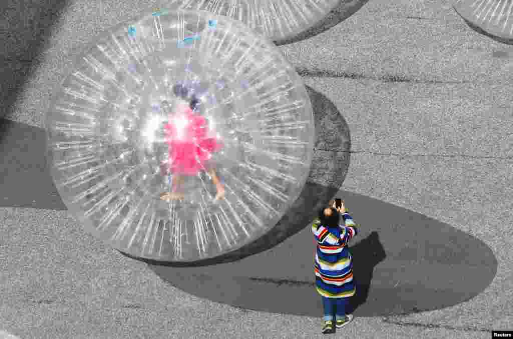 An artist is seen in a transparent plastic ball during the performance &quot;Tears&quot; by Monster Chetwynd in front of the venue of the Art Basel art fair at the Messeplatz square in Basel, Switzerland.