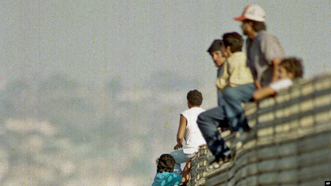 ARSIP – Foto yang diambil tanggal 14 Oktober 1991 ini memperlihatkan sekelompok imigran Meksiko melompati pagar perbatasan untuk memasuki Amerika Serikat, dekat Tijuana, Meksiko (foto: AP Photo/Lenny Ignelzi)