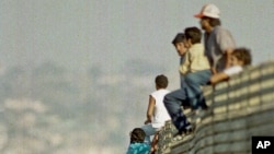 ARSIP – Foto yang diambil tanggal 14 Oktober 1991 ini memperlihatkan sekelompok imigran Meksiko melompati pagar perbatasan untuk memasuki Amerika Serikat, dekat Tijuana, Meksiko (foto: AP Photo/Lenny Ignelzi)