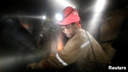 FILE - Miners work deep underground at Sibanye Gold's Masimthembe shaft in Westonaria, South Africa, April 3, 2017.