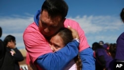 A person living in Mexico embraces a relative living in the U.S. during the annual "Hugs Not Walls" event on a stretch of the Rio Grande in Ciudad Juarez, Mexico, Nov. 2, 2024.