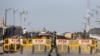 FILE - An Indian security force personnel member walks past barricades during restrictions imposed by authorities following the death of Syed Ali Shah Geelani, a Kashmiri veteran separatist politician, in Srinagar, September 3, 2021. 