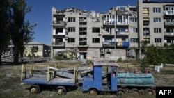 Napušteno dečje igralište pored teško oštećene zgrade u gradu Pokrovsk, Donjecka oblast, 24. septembar, 2024. (Foto: AFP/Genya Savilov)
