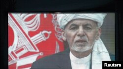 A screen shows the broadcast of Afghanistan's President Ashraf Ghani speaking during his inauguration as president, in Kabul, Afghanistan, March 9, 2020.