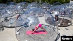 Support bubbles, not real “bubbles," are small groups of people from two households that socialize together. Here, people take an outdoor yoga class by LMNTS Outdoor Studio using a real half bubble, or dome, to prevent the spread of COVID-19 in Toronto, Canada June 21, 2020.