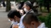 Personas que usan máscaras protectoras para ayudar a frenar la propagación del coronavirus descansan en un parque el miércoles 14 de octubre de 2020 en Tokio.