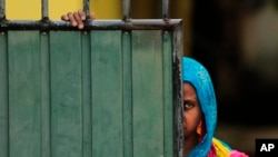 FILE - A Sri Lankan Muslim woman looks out on the street, in Aluthgama, town, 50 kilometers (31.25 miles) south of Colombo, Sri Lanka.