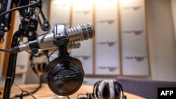 FILE - A microphone and headsets are seen in a radio broadcast studio.