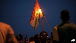 A protestor holds a Burkina Faso national flag during a protest against a recent coup in Ouagadougou, Burkina Faso, Sept. 21, 2015.