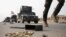 An Iraqi special forces soldier runs as other drive in armored vehicles on a road near Mosul, Iraq, Oct. 25. 2016.