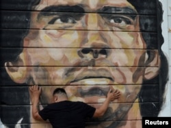 A fan reacts while mourning the death of soccer legend Diego Armando Maradona, outside the Diego Armando Maradona stadium, in Buenos Aires, Argentina, Nov. 25, 2020.