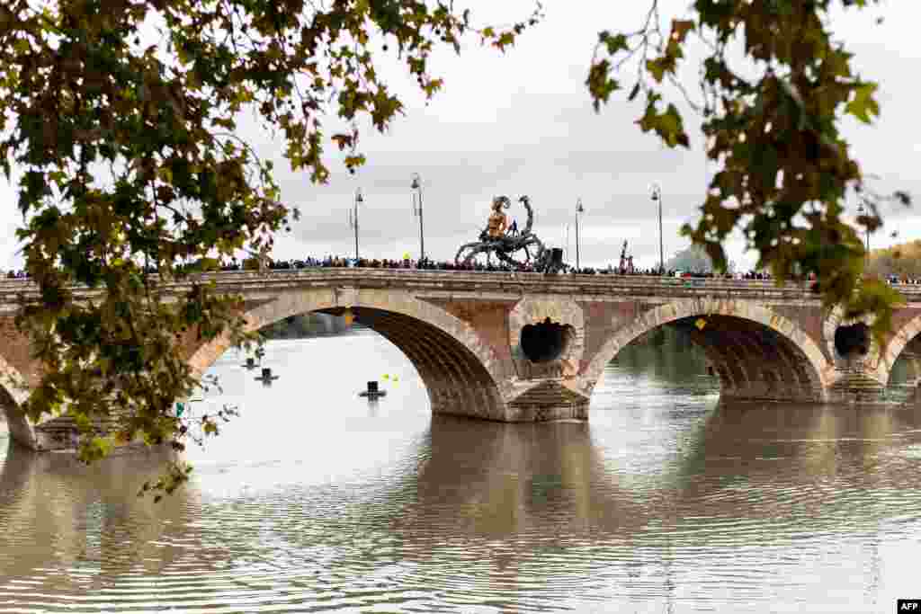 Spectators watch the human head scorpion and spider creature, &quot;Lilith, the guardian of darkness&quot; parading on a bridge during the major street show &quot;The Guardian of the Temple opus II: The Portal of Darkness&quot; by French company La Machine, in Toulouse, southwestern France.