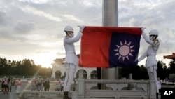 资料照：2022年7月30日，台湾台北，在中正纪念堂自由广场举行的每日升旗仪式上，两名士兵折叠国旗。（美联社）