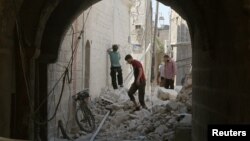 Residents inspect their damaged homes after an airstrike on the rebel-held Old Aleppo, Syria, Aug. 15, 2016.