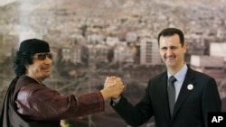 En mars 2008, le leader Lybien de l'epoque Moammar Gadhafi gesticulant avec le president Syrien Bashar Assad, pendant l'ouverture du Sommet arabe a Damascus, Syria. 