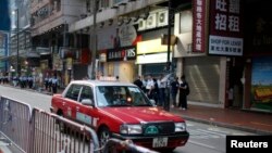 Sebuah taksi melintasi jalanan di pusat perdagangan Causeway Bay, Hong Kong (Foto: dok). Pihak berwenang China menjanjikan perubahan dalam industri taksi pasca pemogokan para supir di sedikitnya tujuh kota utama negara itu.