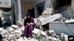 Artist Saja Moussa draws on broken tiles from her family's house in Rafah refugee camp, southern Gaza Strip, June 15, 2021.