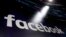 FILE - The logo for Facebook appears on screens at the Nasdaq MarketSite in New York's Times Square, March 29, 2018. 