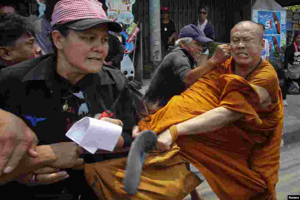 Members of the pro-government &quot;red shirt&quot; movement attack a Buddhist monk outside the National Anti-Corruption Commission office in Nonthaburi province, on the outskirts of Bangkok, China. 