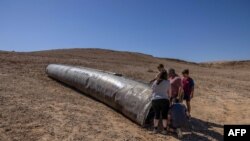 People visit the site of the remains of an Iranian missile in the Negev desert near Arad on October 3, 2024, in the aftermath of an Iranian missile attack on Israel.