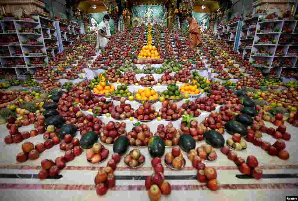 Priests arrange fruits offered by Hindu devotees inside a temple to mark the Annakut festival in Ahmedabad, India.