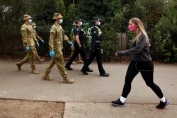 ADF personnel and Victorian police officers patrol a walking track as Melbourne remains in lockdown restrictions due to outbreaks of the coronavirus in Melbourne, Australia, July 26, 2020.