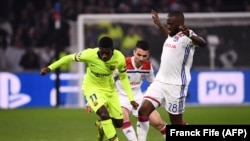 L'attaquant français de Barcelone Ousmane Dembélé (g) rivalise avec l'attaquant français de Lyon Tanguy Ndombélé lors du match entre l'OL et le FC Barcelone le 19 février 2019, au stade Groupama à Decines en France.