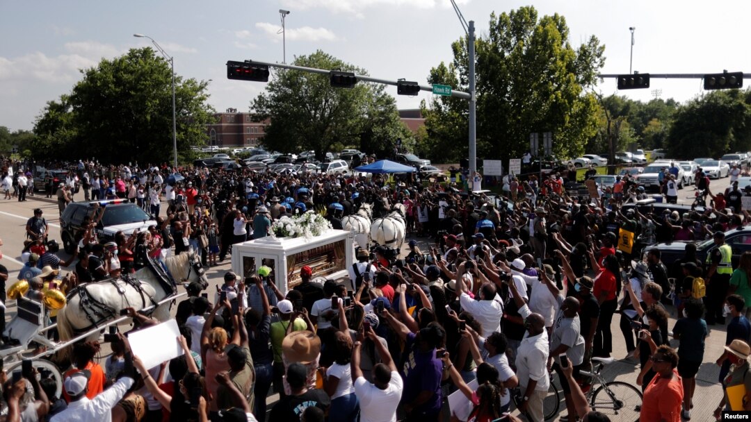 People gather as the horse-drawn carriage carrying the casket containing the body of George Floyd, passes by on its way to Houston Memorial Gardens cemetery in Pearland, Texas, June 9, 2020. 