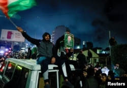 Seorang warga memegang poster bergambar mendiang pemimpin Hamas Yahya Sinwar di Ramallah, Tepi Barat, 20 Januari 2025. (Foto: REUTERS/Ammar Awad)