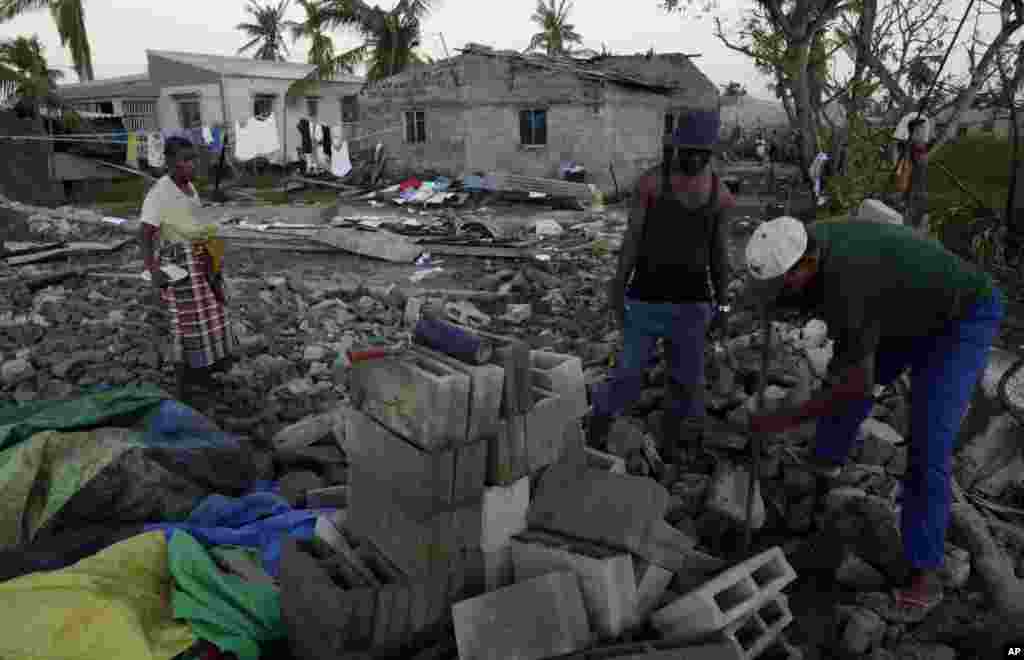 Membros de uma igreja tentam recolher blocos de tijolos de uma igreja destruída na Beira,&nbsp; 25 de Março, 2019.