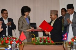 FILE - Nepal's Foreign Secretary Shankar Das Bairagi and China's Ambassador to Nepal Yu Hong, second from left, exchange documents during a signing ceremony relating to the One Belt One Road initiative in Kathmandu, May 12, 2017.