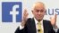 FILE - Australian Prime Minister Malcolm Turnbull raises his hands as he speaks during a leaders debate hosted by Facebook Australia and News.com.au in Sydney, June 17, 2016. The Australian government on July 14, 2017, proposed a new cybersecurity law to force global technology companies such as Facebook and Google to help police by unscrambling encrypted messages sent by suspected extremists and other criminals. 