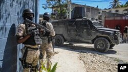 হাইতির পোর্ট-অ-প্রিন্সে কর্তব্যরত অবস্থায় নিহত ৩ পুলিশ কর্মকর্তার অন্ত্যোষ্টিক্রিয়ার সময় পুলিশ একাডেমির সামনে পাহারারত পুলিশ সদস্য; ৩১ জানুয়ারি ২০২৩। ২০২৩ সালের ৯ এপ্রিল একটি অতর্কিত হামলায় আরো ৩ জন কর্মকর্তা নিহত হন।