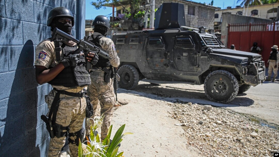 Police stand guard in front of the Police Academy during a funeral of three police officers killed in the line of duty in Port-au-Prince, Haiti, Jan. 31, 2023. On April 9, 2023 three more officers were killed in an ambush.
