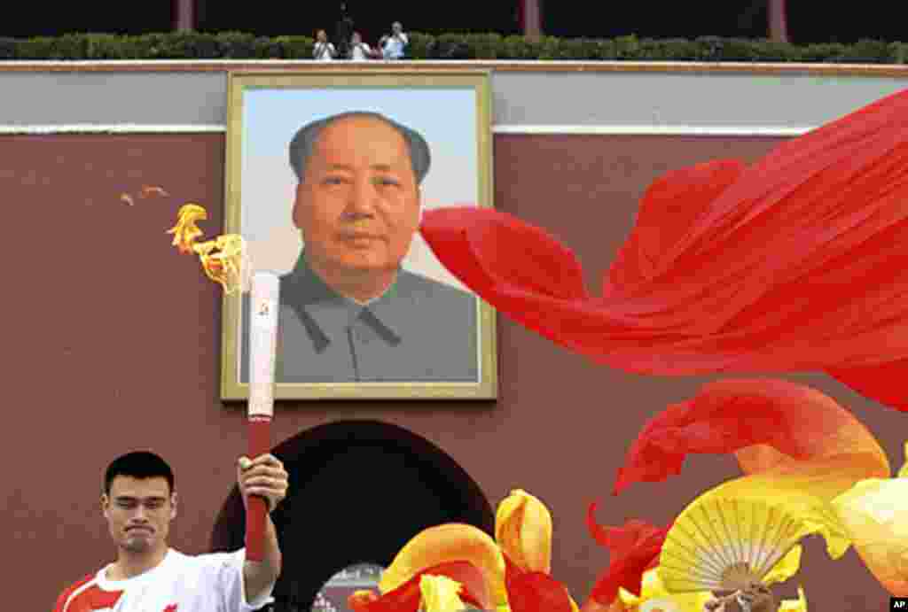 Yao Ming holds a torch as he runs through the Tiananmen Gate during the 2008 Beijing Olympics torch relay in Beijing, August 6, 2008 (Reuters).
