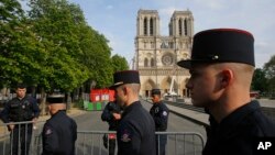 Members of Paris Firefighters' brigade enter the security perimeter to Notre Dame cathedral in Paris, April 18, 2019. France paid a daylong tribute Thursday to the Paris firefighters who saved Notre Dame Cathedral from collapse.