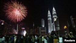 Kembang api berpendar dekat menara kembar Petronas di Kuala Lumpur.