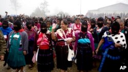 FILE - Maria de Jesus Patricio, presidential candidate for the National Indigenous Congress, campaigns with an escort of masked indigenous women in the Zapatista stronghold of Oventic in the southern state of Chiapas, Mexico, Oct. 19, 2017. Independent candidates are being forced to use a smartphone app to collect the hundreds of thousands of signatures they need to get on the ballot in a country where coverage is spotty and a minority can afford smartphones.
