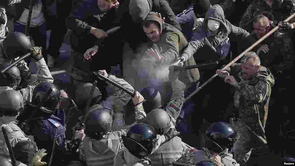 Protesters, right, clash with Interior Ministry and law enforcement members during a rally near the parliament building in Kyiv, Oct. 14, 2014. Thousands of Svoboda nationalist party supporters rallied in Kyiv earlier Tuesday in celebration of the Ukrainian Insurgent Army, but officials from the party denied vehemently that its members were involved in the unrest. 