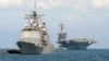 FILE - The cruiser USS Bunker Hill, left, and the U.S. aircraft carrier Carl Vinson sit anchored off Manila Bay after arriving on May 15, 2011.
