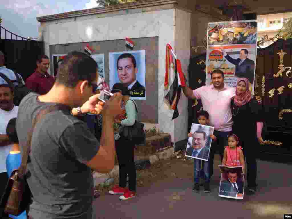 An Egyptian family poses for a portrait holding Mubarak&#39;s poster in front of Maadi Military hospital in 2015. (Photo: Hamada Elrasam / VOA) 