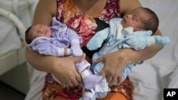 Severina Raimunda holds her granddaughter Melisa Vitoria, left, who was born with microcephaly and her twin brother, Edison Junior, at the IMIP hospital in Recife, Pernambuco state, Brazil, Feb. 3, 2016. 