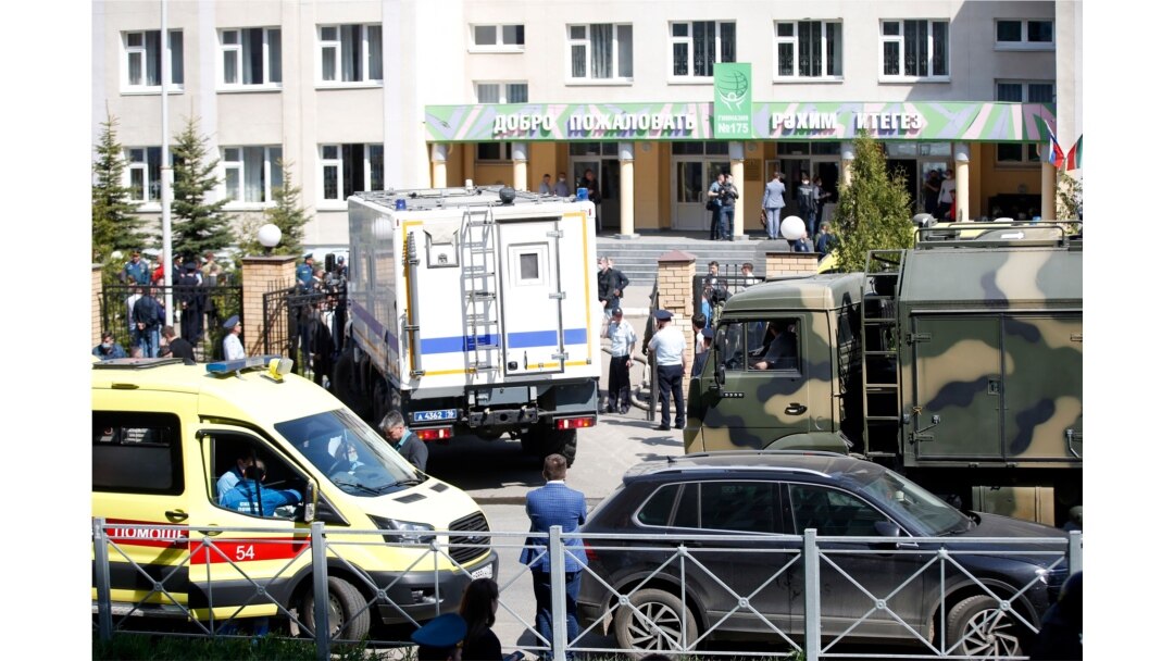 Sebuah ambulans dan truk polisi diparkir di sebuah sekolah usai penembakan di Kazan, Rusia, Selasa 11 Mei 2021. Media Rusia melaporkan bahwa beberapa orang tewas dan terluka dalam penembakan di sekolah di kota Kazan, Rusia.